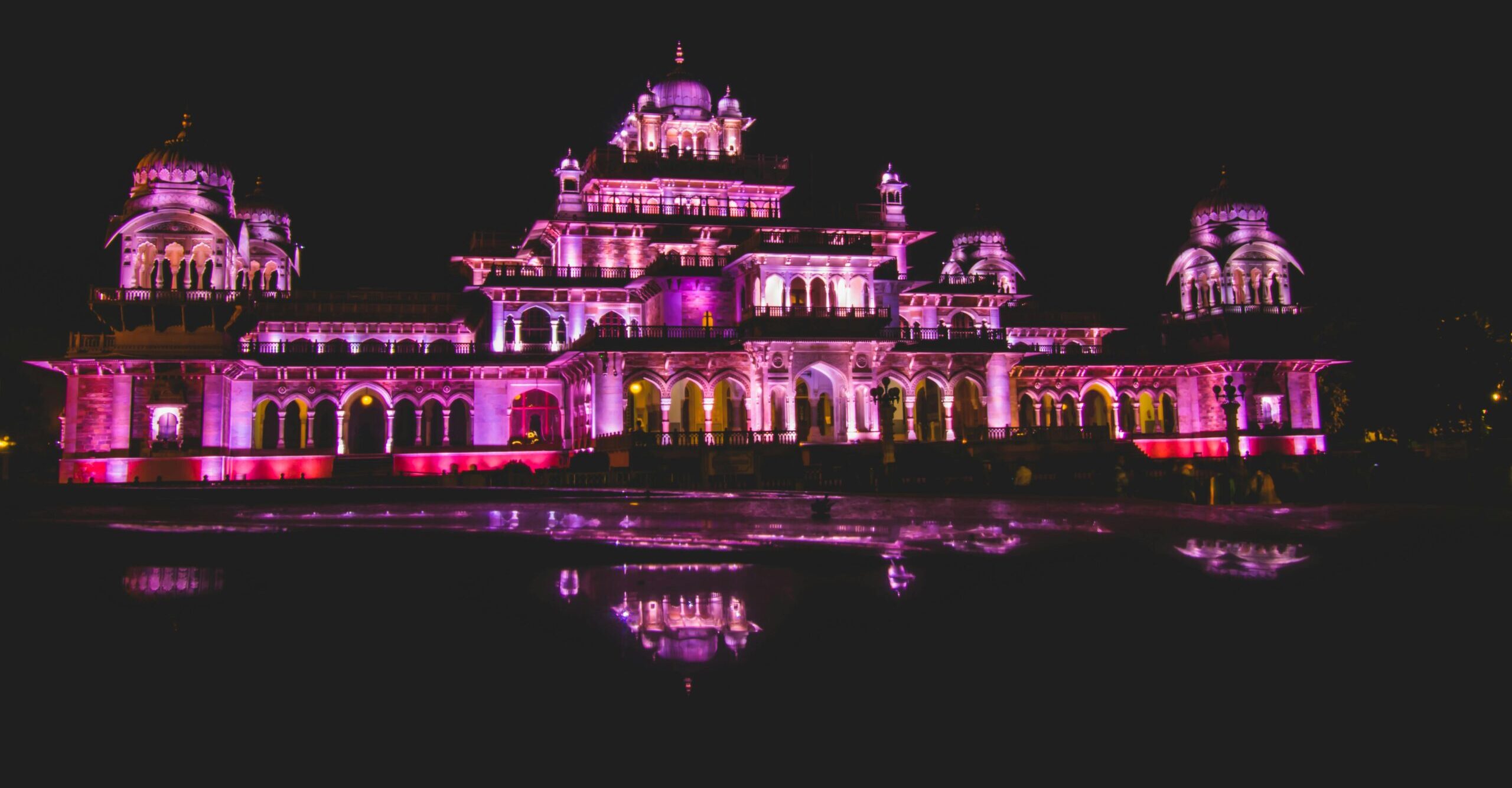 Dazzling illuminated night view of Albert Hall Museum in Jaipur, showcasing its architectural beauty and reflection.